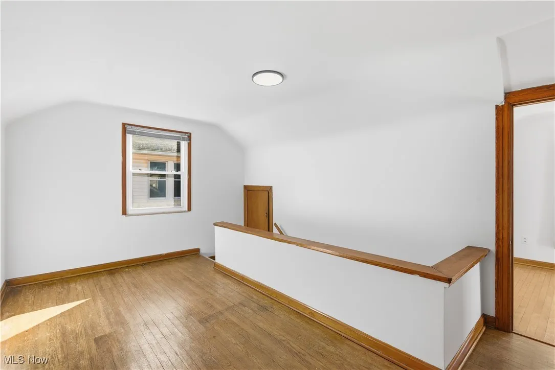 Bonus room with light wood finished floors and vaulted ceiling
