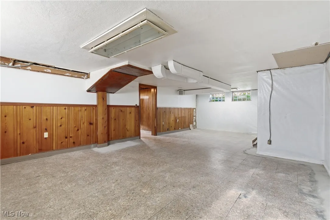 Garage featuring wood walls and a wainscoted wall