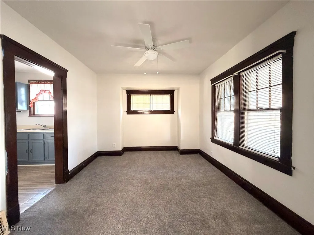 Spare room with dark colored carpet and ceiling fan