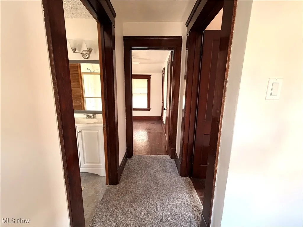 Hall with a sink and dark carpet