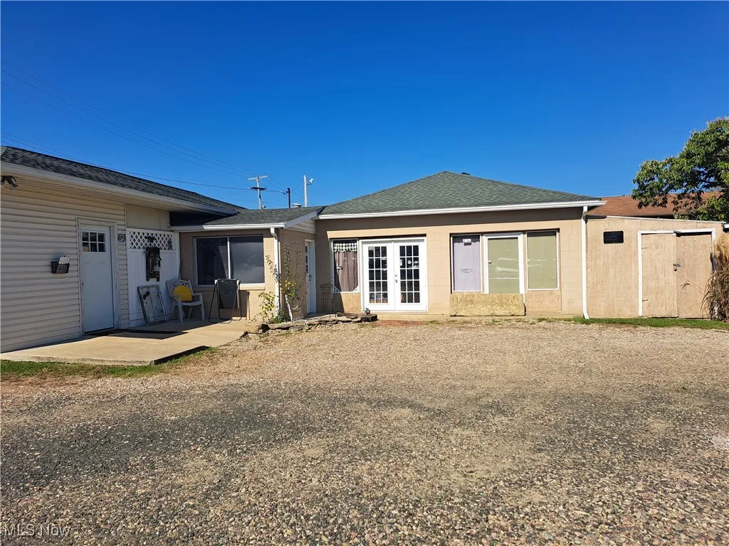 Back of building with double doors to workroom and storage shed