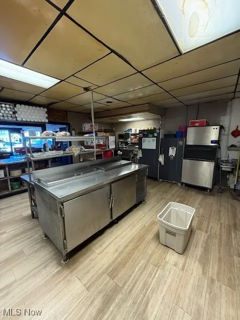 Kitchen with a paneled ceiling, a kitchen island, and refrigerator