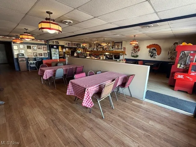 Dining area with a drop ceiling and wood finished floors