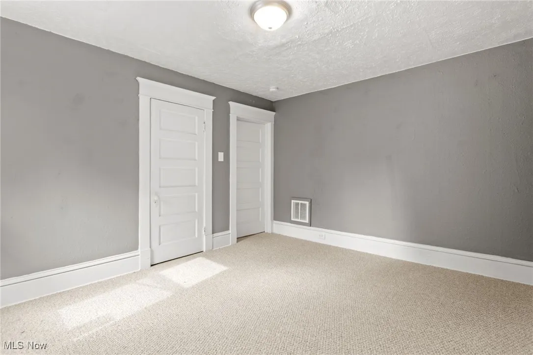Unfurnished bedroom with carpet flooring and a textured ceiling
