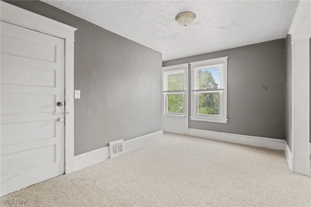 Empty room with carpet flooring and a textured ceiling