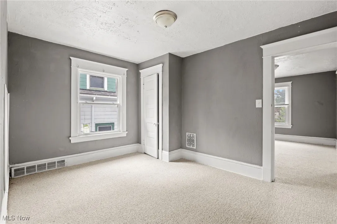 Empty room featuring carpet flooring and a textured ceiling