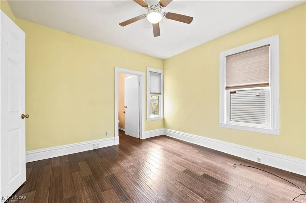 Empty room featuring dark wood finished floors and ceiling fan