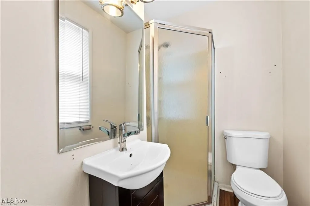 Full bathroom with vanity and a shower stall