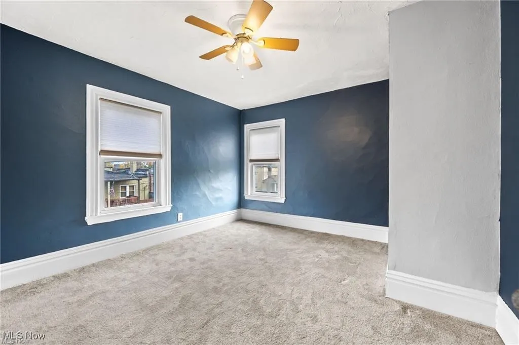 Unfurnished room with carpet flooring, plenty of natural light, and a ceiling fan