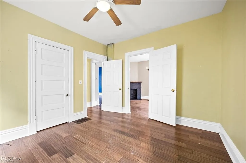 Unfurnished bedroom featuring dark wood finished floors, ceiling fan, and a closet