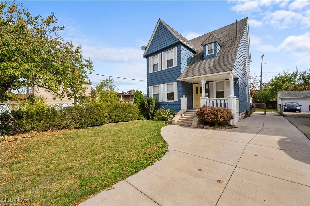 Victorian-style house with a front yard, covered porch, and a shingled roof