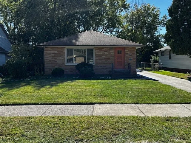 View of front of property with brick siding and a front lawn