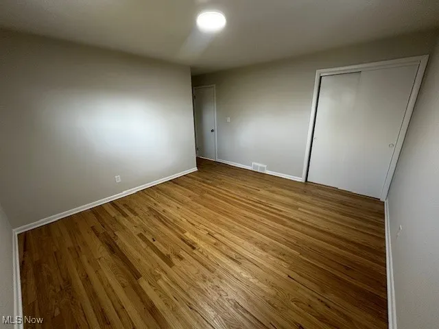 Unfurnished bedroom with a closet and wood finished floors