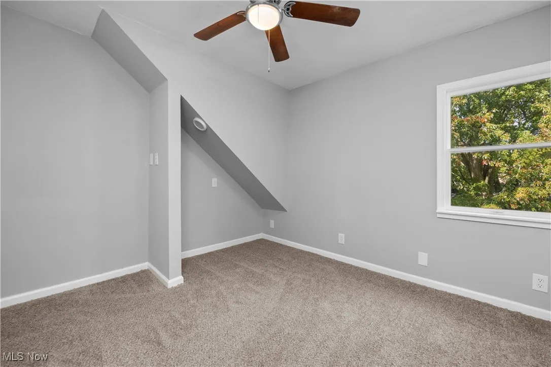 Unfurnished room with light carpet and a ceiling fan