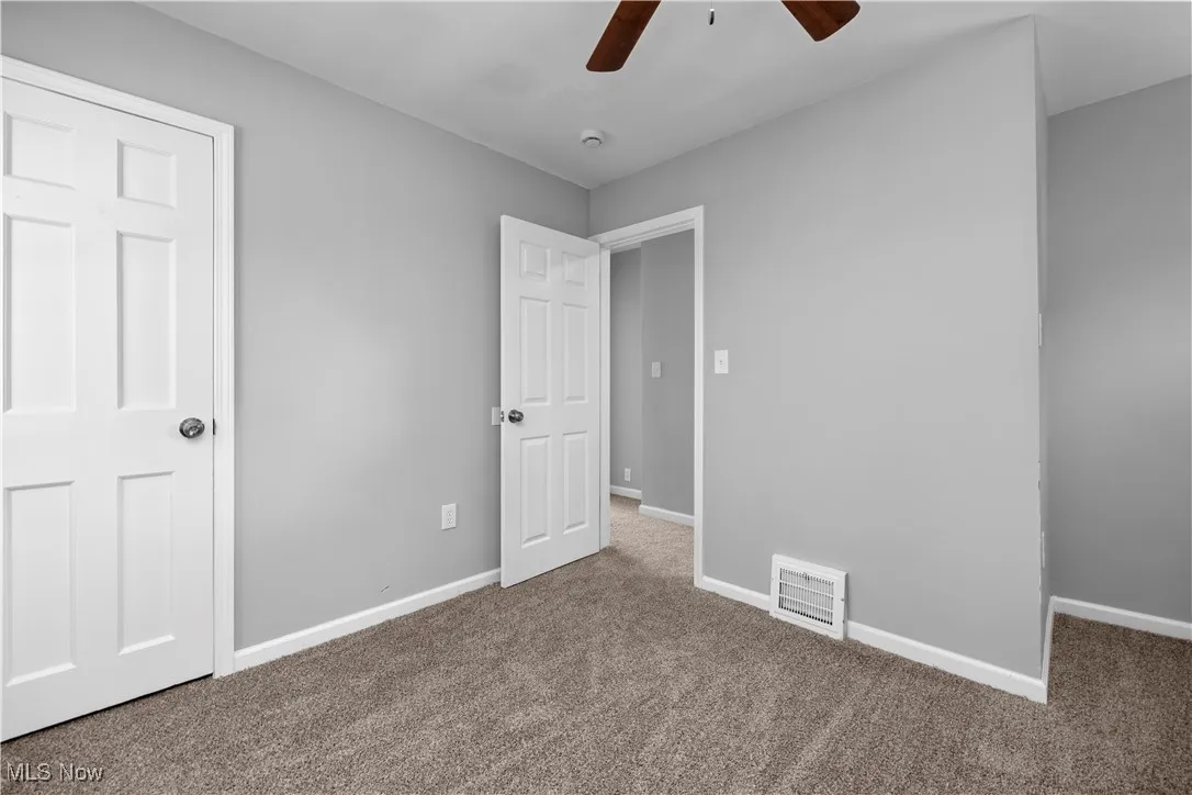Unfurnished bedroom with carpet and a ceiling fan