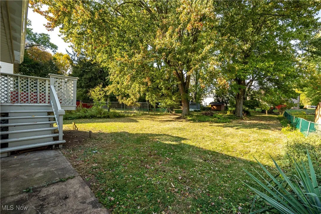 Fenced backyard featuring stairs and a deck