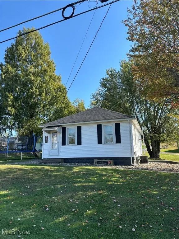 View of front facade featuring a sidewalk and a front lawn