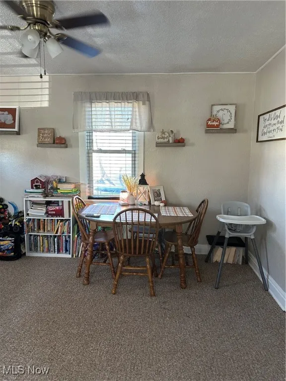 Dining room with carpet, a textured ceiling, and ceiling fan