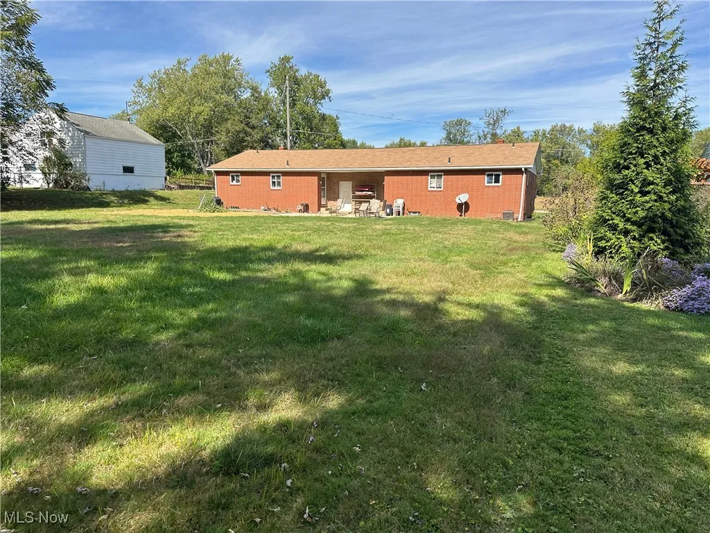 Back of property with a patio area and a yard