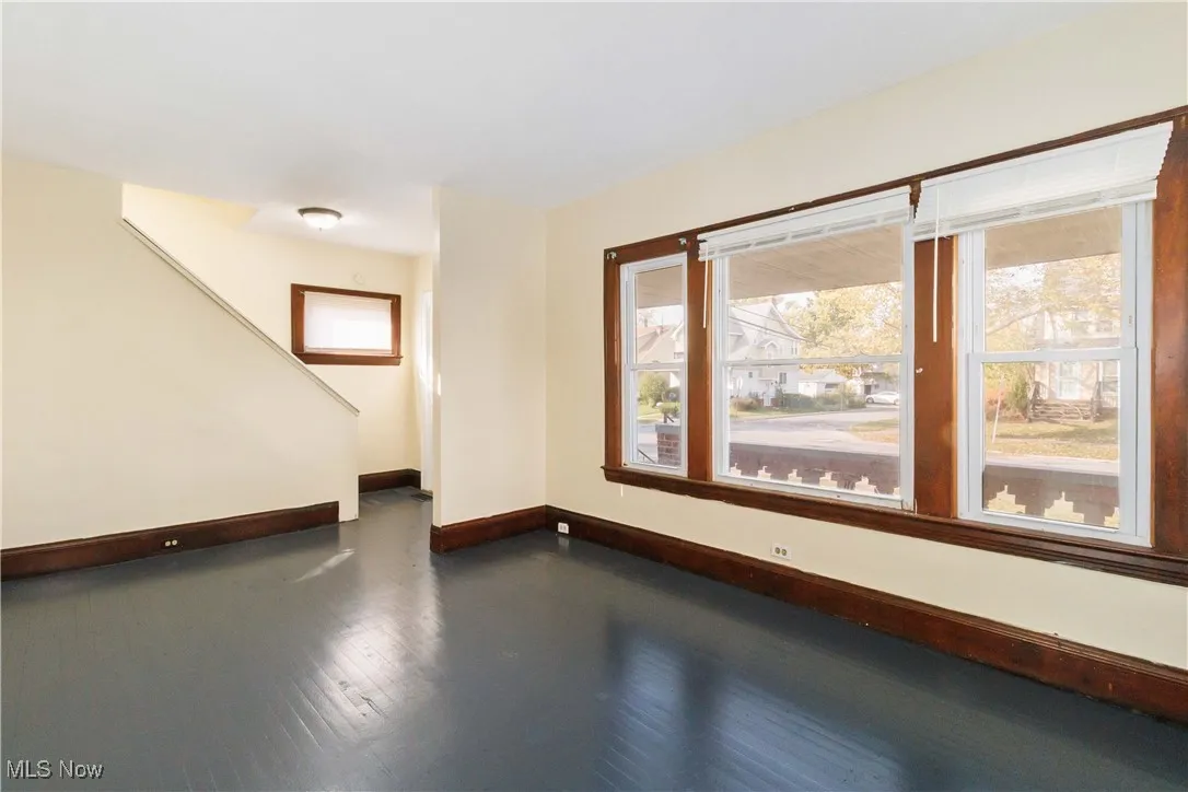 Empty room featuring healthy amount of natural light and dark wood finished floors