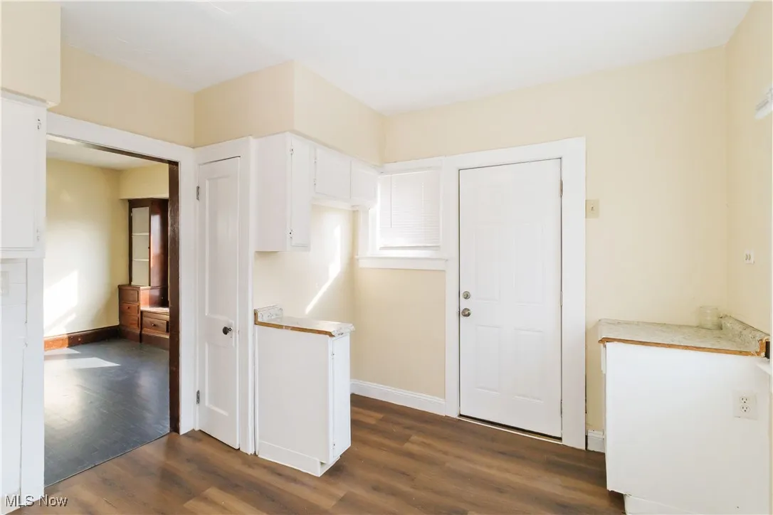 Kitchen featuring light countertops, white cabinets, and dark wood finished floors