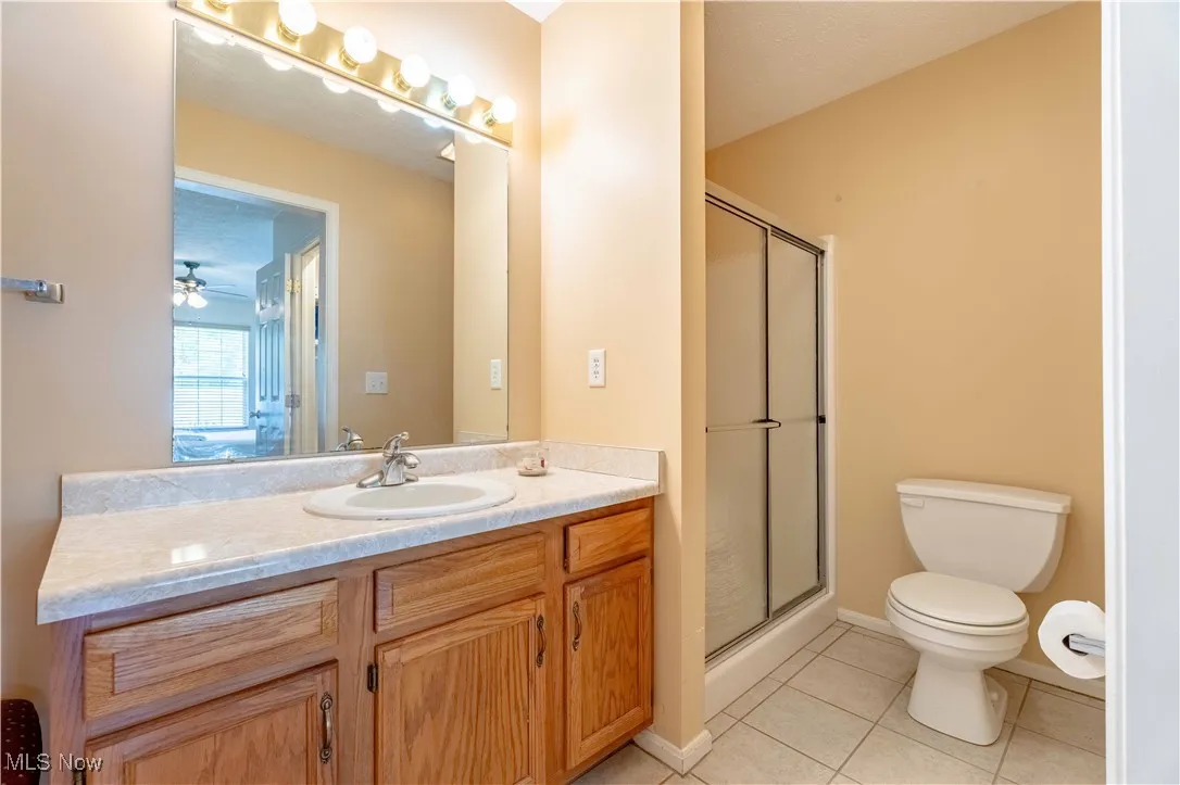 Bathroom featuring a shower stall, vanity, and tile patterned flooring