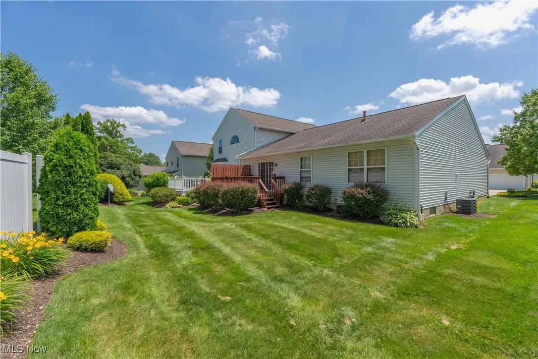 Rear view of house with a deck and a yard