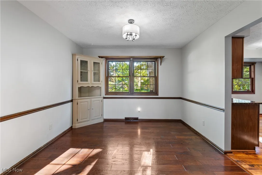 dining room with dark wood finished floors and a textured ceiling
