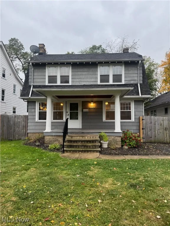 View of front facade with a chimney, a porch, and a shingled roof