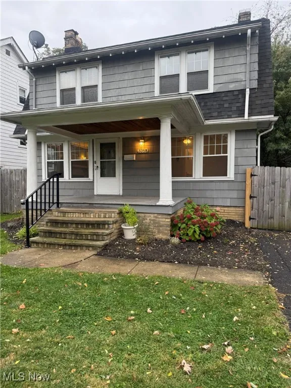 View of front of home featuring a chimney and a porch