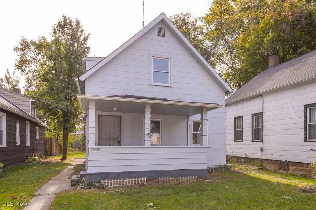 Rear view of house with a lawn and covered porch
