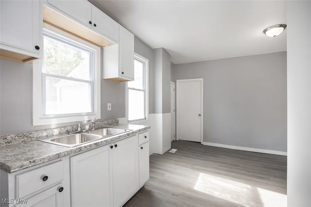 Kitchen with white cabinets, light wood-style floors, and light countertops