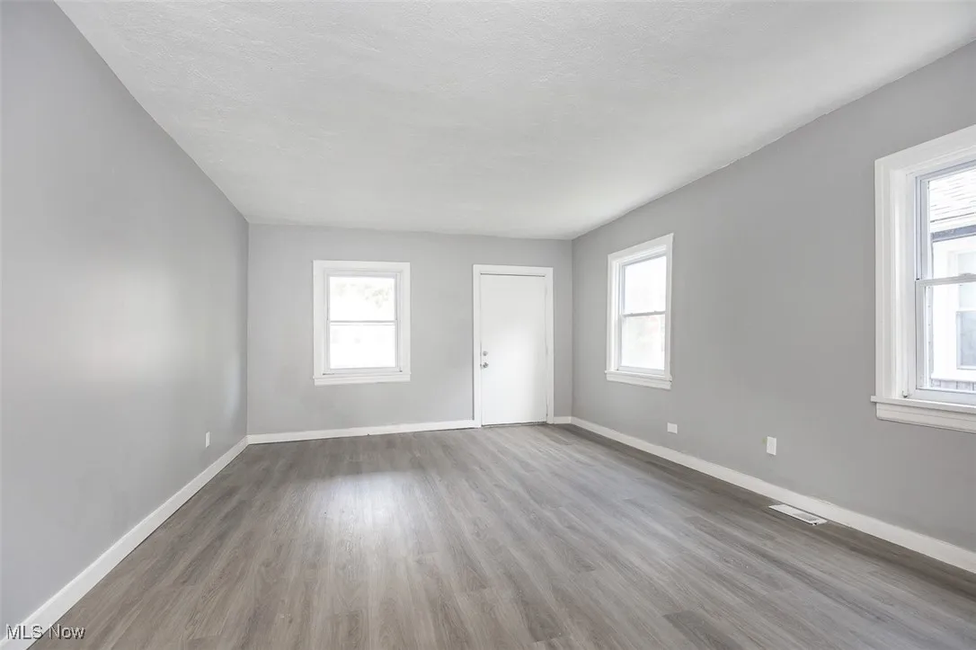 Spare room with wood finished floors and a textured ceiling