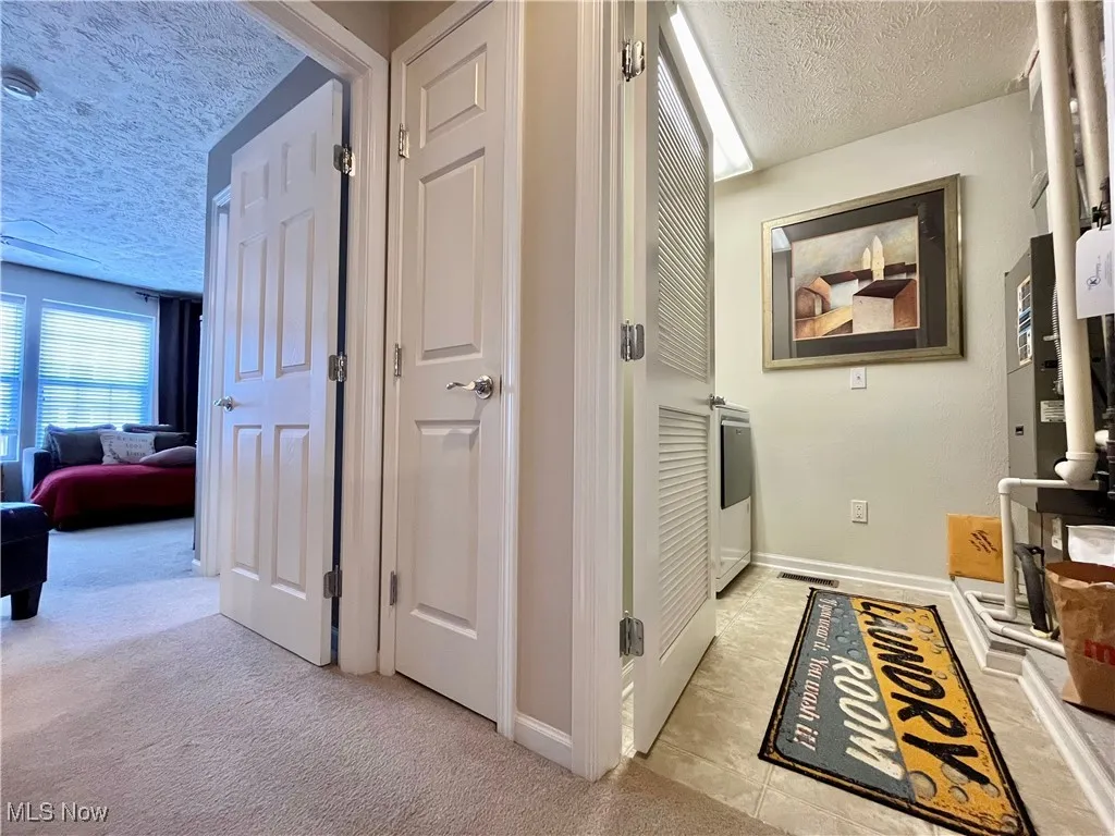 Hall viw of laundry room and primary bedroom