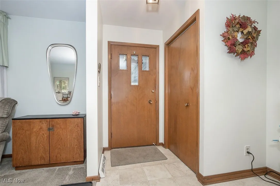 Foyer entrance with baseboards and light tile patterned floors