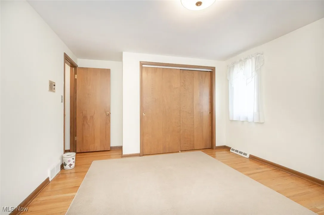 Unfurnished bedroom with light wood-type flooring and a closet
