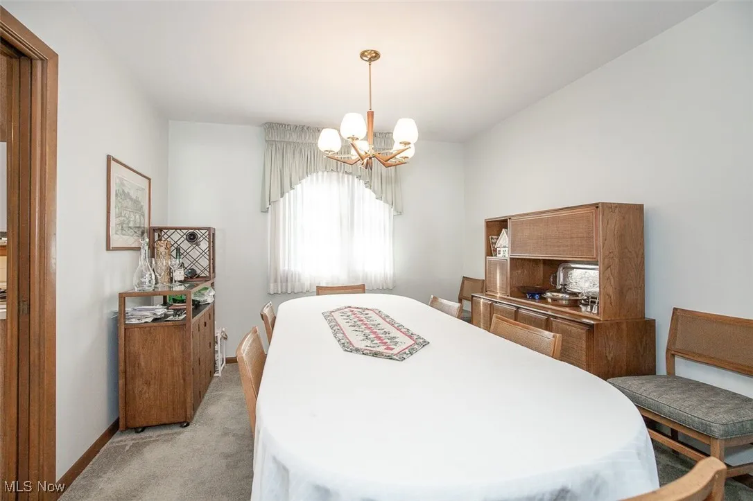 Bedroom with light carpet and a chandelier