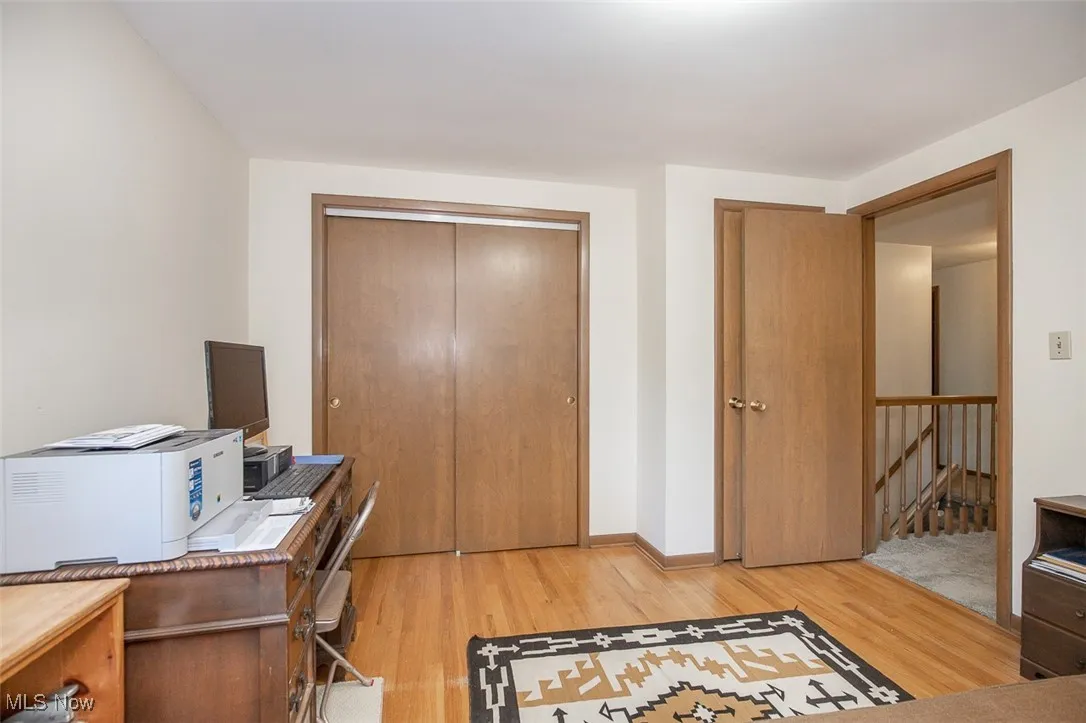 Home office with light wood-style flooring and baseboards
