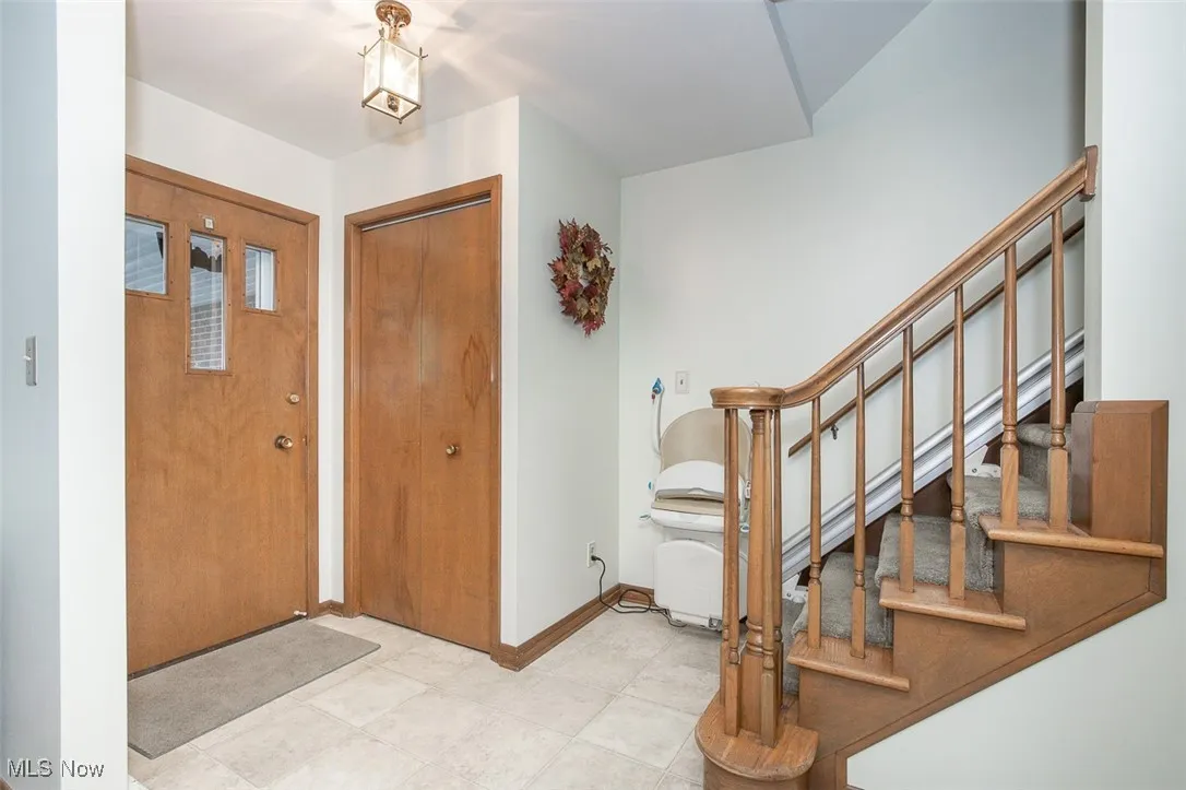 Foyer with baseboards and stairs