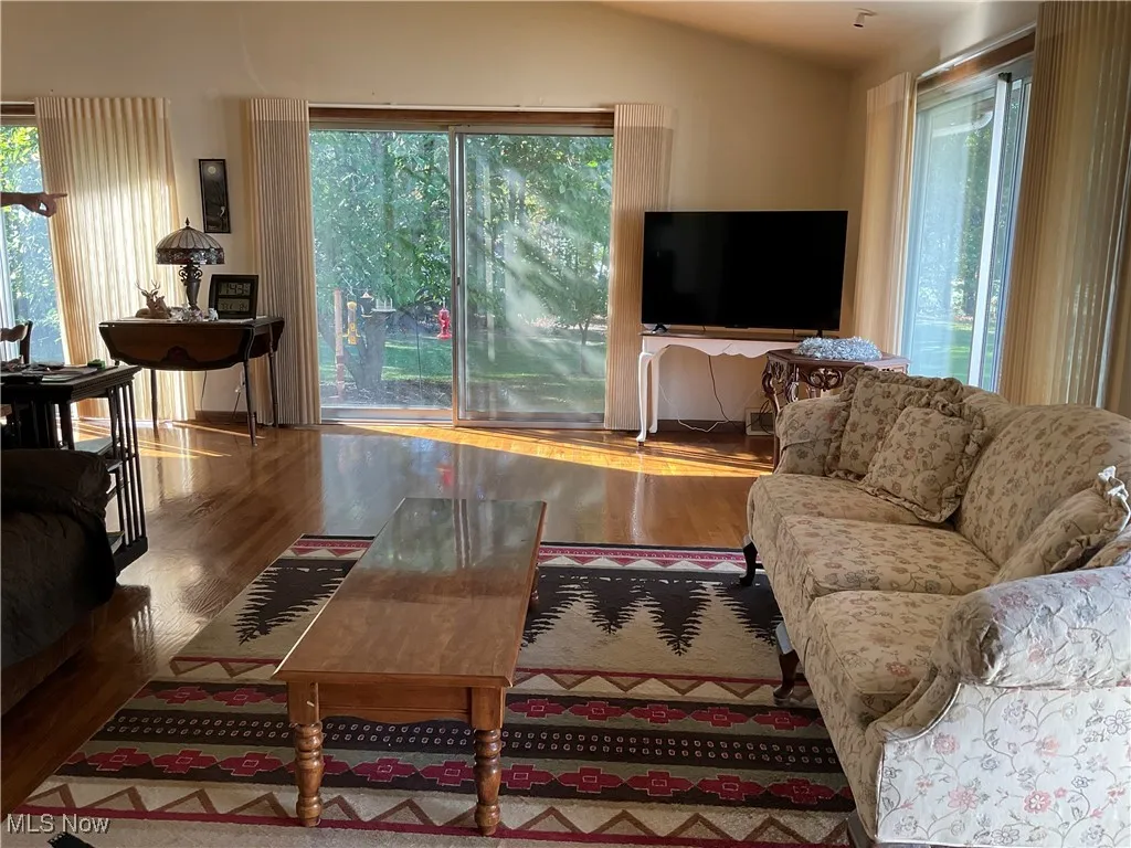 Living area with wood finished floors and vaulted ceiling