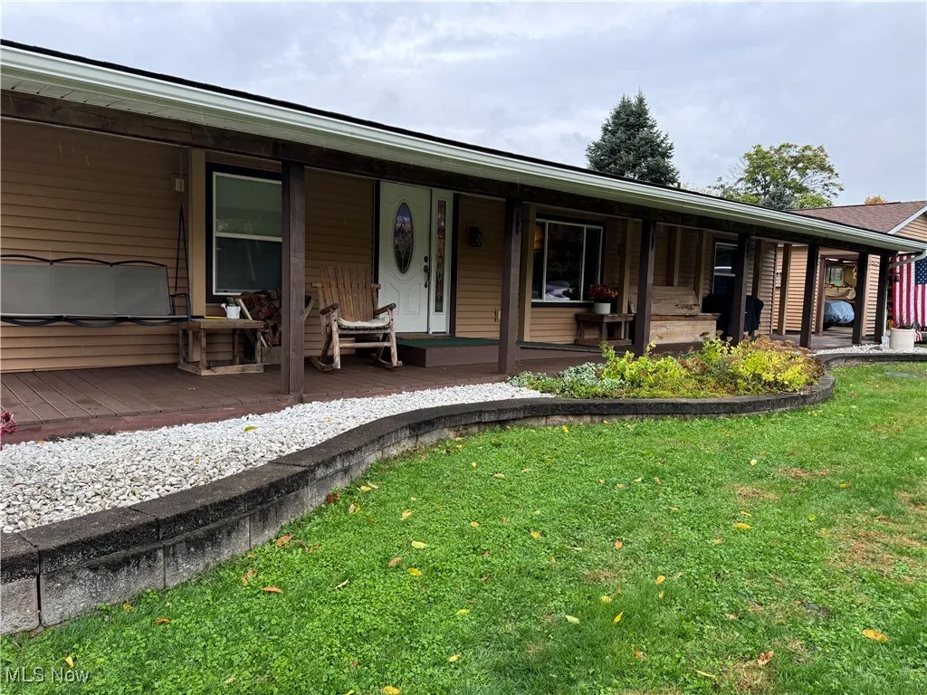 View of front of property with a front yard and covered porch
