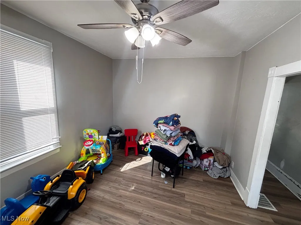 Living room with wood finished floors and a ceiling fan