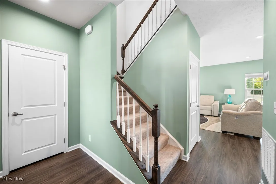 Staircase with wood finished floors and recessed lighting