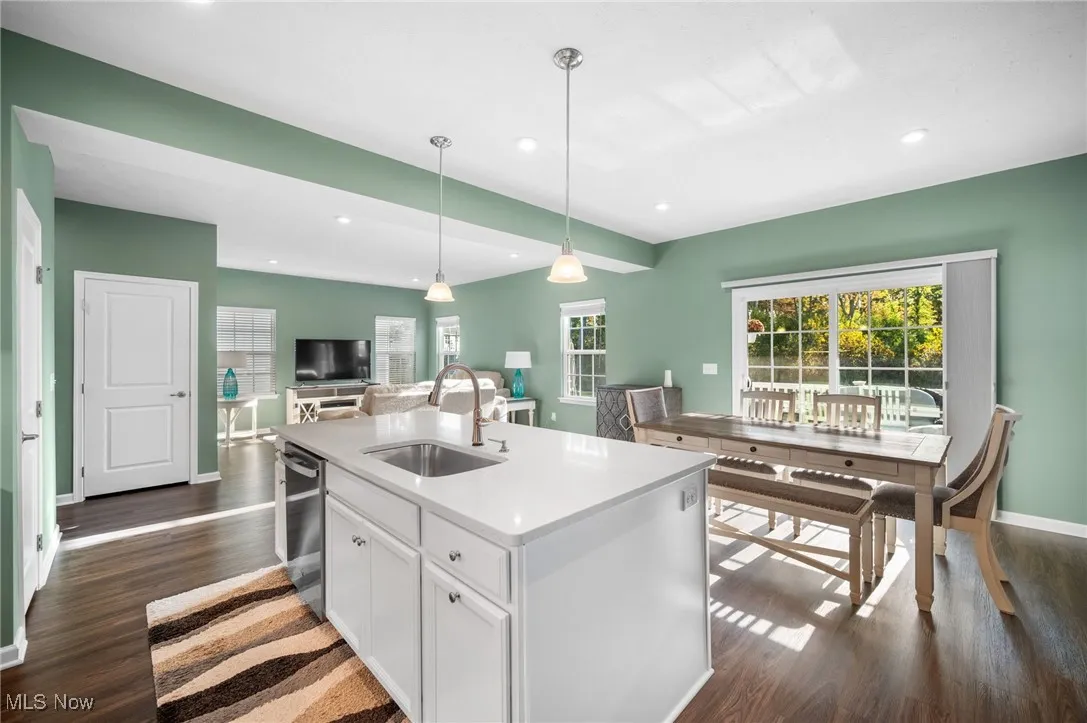 Kitchen featuring white cabinets, dark wood finished floors, open floor plan, a kitchen island with sink, and recessed lighting