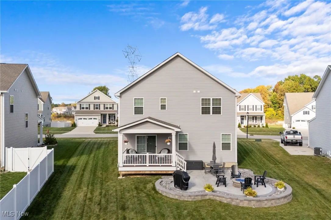 Back of property featuring a patio area, a residential view, a wooden deck, and an outdoor fire pit
