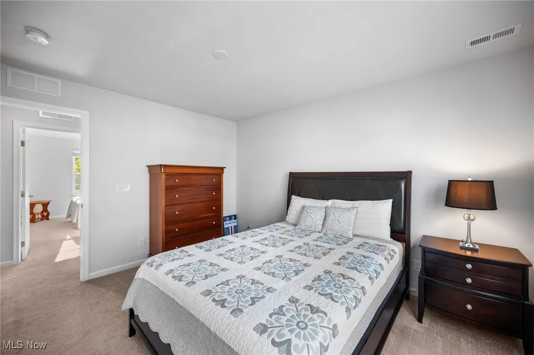 Bedroom featuring light colored carpet and baseboards