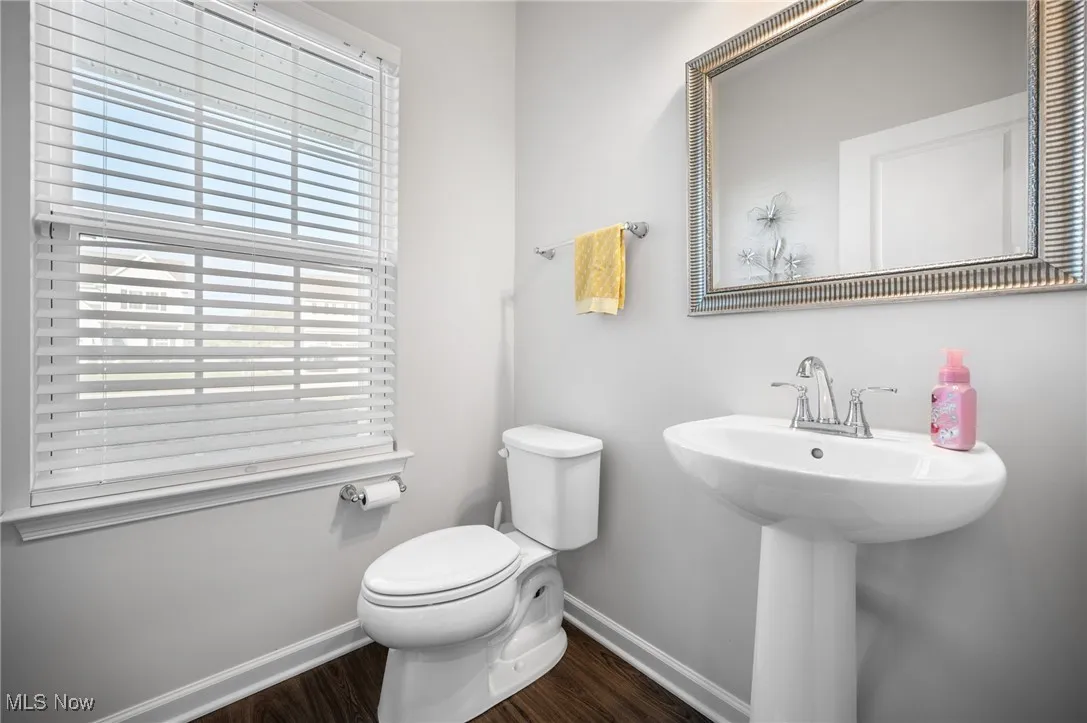 Half bath featuring baseboards and dark wood-style flooring
