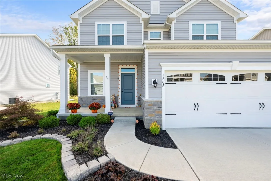 View of front of home featuring covered porch and stone siding