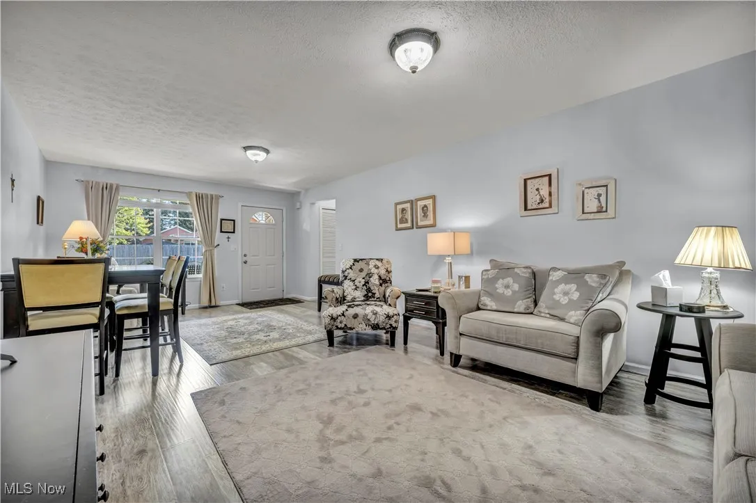 Living room with a textured ceiling and light wood-type flooring