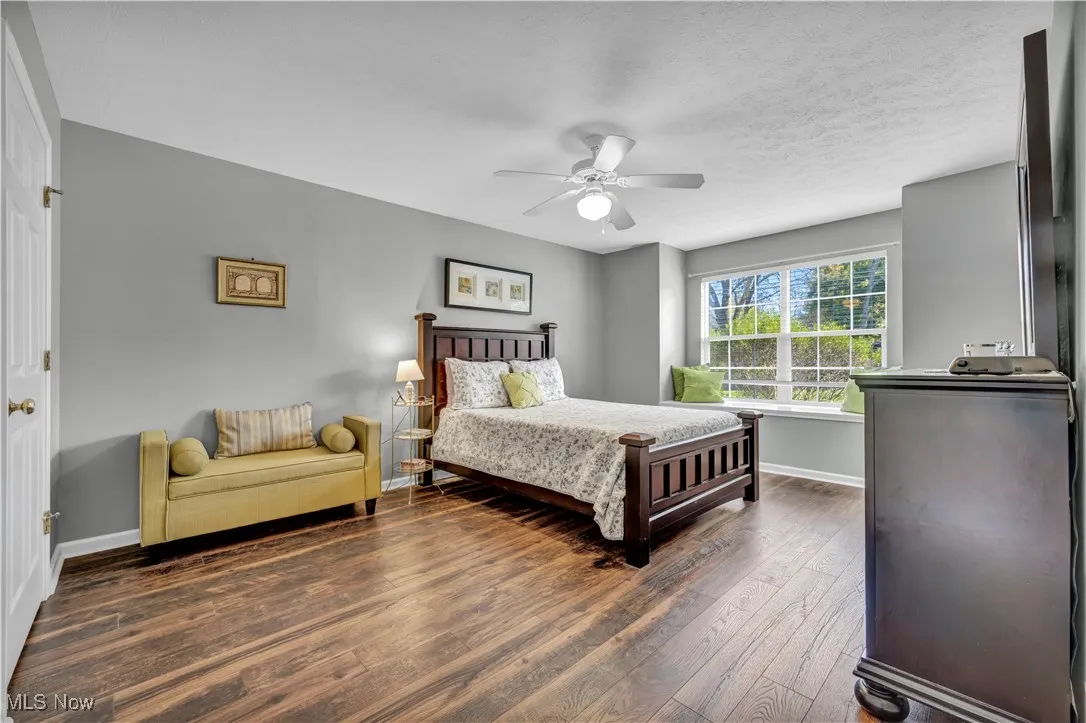 Bedroom with dark wood-type flooring and a ceiling fan
